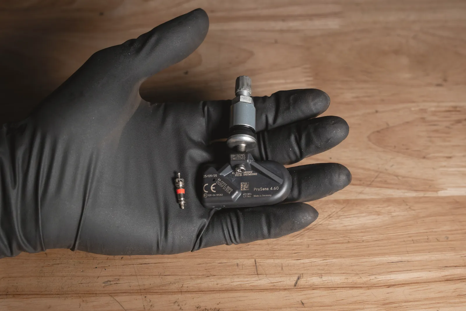 Reifendrucksensor und neues Ventil in der Hand bei FA-CARSERVICES